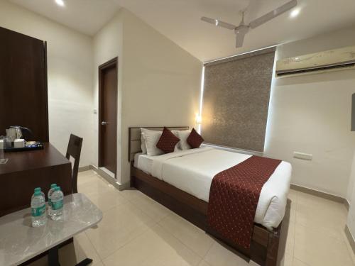 a hotel room with a bed and a desk and a bed sidx sidx sidx sidx at Hotel Maritan - Hitech City, Hyderabad in Hyderabad