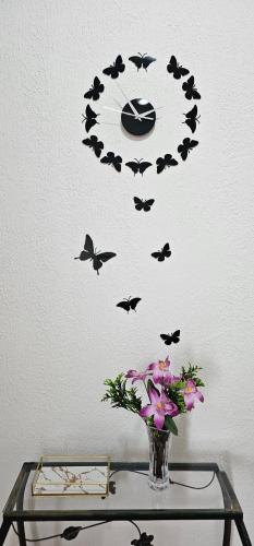 a vase with flowers and bats on a table at Doce refúgio - Aconchegante e completo in Uberaba