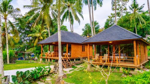 a cabin in the middle of a resort with palm trees at Taman Swarga Villa Resort & Spa Sidemen in Sidemen