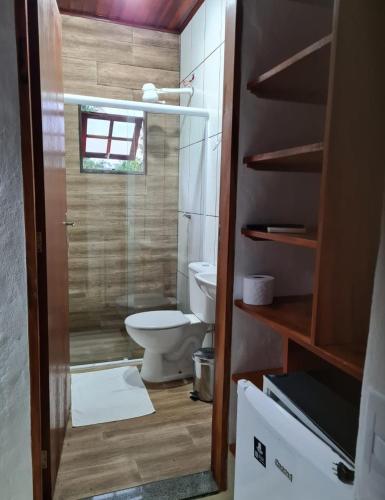 a small bathroom with a toilet and a window at Pousada Refugio Prumirim in Ubatuba