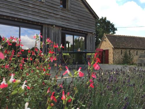 a garden with flowers in front of a house at Country-side house close to loire-valley castles in Sargé-sur-Braye