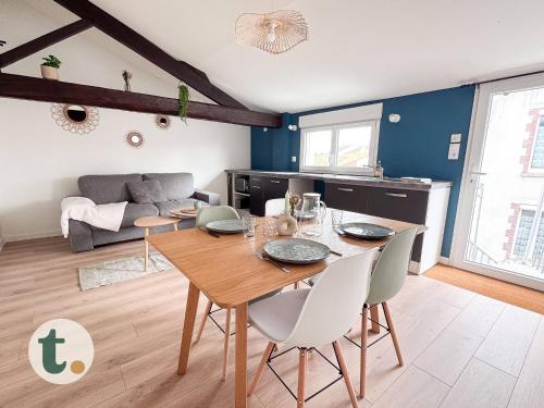 un salon avec une table et des chaises en bois dans l'établissement Tranquiloue - Petit Appartement - 10min Puy du Fou, aux Herbiers