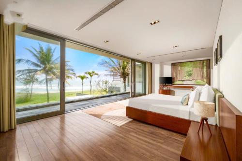 a bedroom with a bed and a large window at Danang Villas Complex in Da Nang