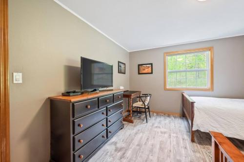 a bedroom with a bed and a dresser with a television at Bjork Creek Cabin in Leavenworth