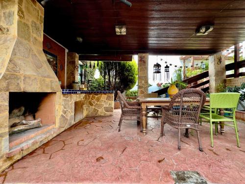 a patio with a table and chairs and a stone fireplace at Villa Tortuga 2 BR 2 BA in Playas de Tijuana in Tijuana