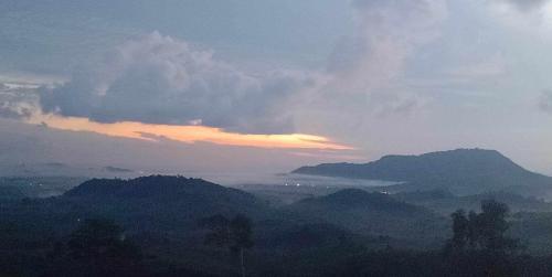 a view of a mountain range with a cloudy sky at Baan Namthip Homestay Trang บ้านน้าทิพย์ โฮมสเตย์ตรัง in Ban Huai To (1)