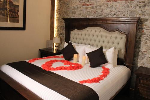 a bedroom with a bed with red flowers on it at HOTEL BOUTIQUE CASONA 65 in Puebla