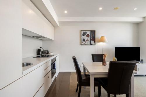 a kitchen with a table and chairs in a room at Swainson on Balfours in Adelaide
