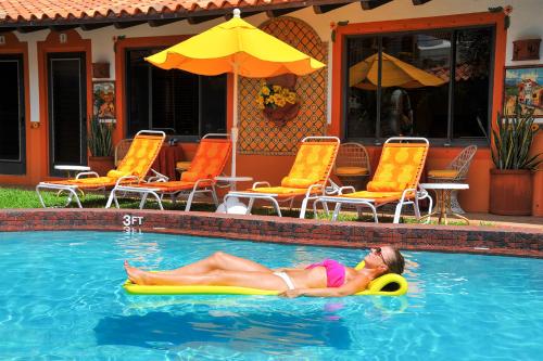 a woman laying on a raft in a swimming pool at Blue Seas Courtyard in Fort Lauderdale