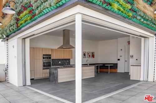 a kitchen with an open garage with a counter top at Modern Hollywood Walk of Fame Apts- Free Parking, 360 Rooftop, Pool, Gym- Centrally located in Los Angeles