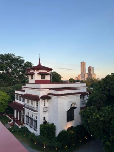 a white building with a tower on top of it at MiraNamin Nest GUMAMELA Suite in Unique Historic Home with View, Pet Friendly with a Fee in Manila