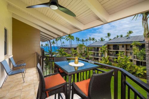 a patio with a table and chairs on a balcony at Ocean view with Loft in Kailua-Kona