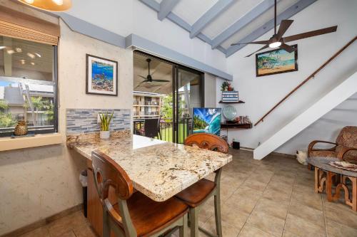 a kitchen with a counter and chairs and a table at Ocean view with Loft in Kailua-Kona