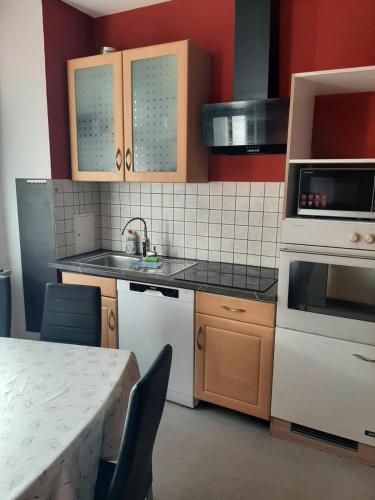 a kitchen with white appliances and a table with chairs at Stadtblick 1 Monteuersfreud in Eisenberg