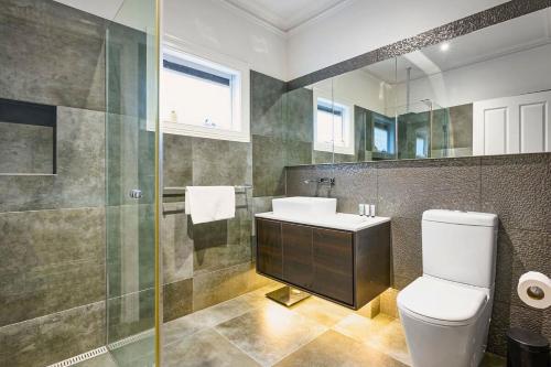 Un baño con inodoro, lavabo y ducha. en Bowen Street Family Retreat with Pool, en Melbourne