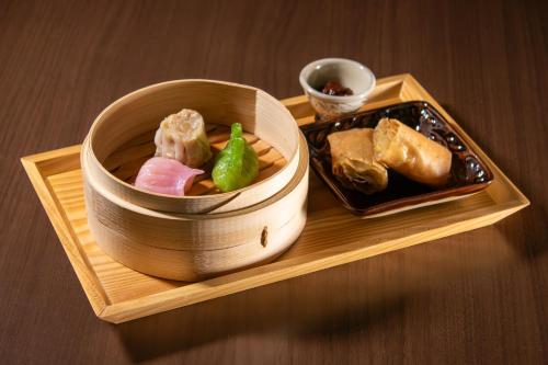 a wooden tray with a bowl of food on a table at Loisir Hotel Naha in Naha