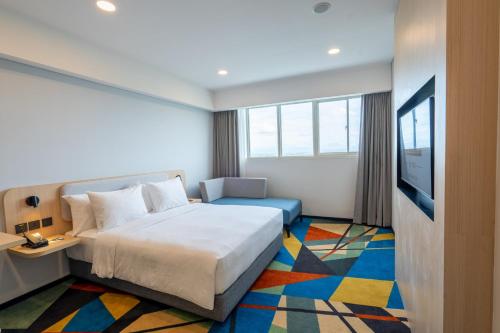a hotel room with a bed and a television at Holiday Inn Express & Suites Banjarmasin by IHG in Banjarmasin