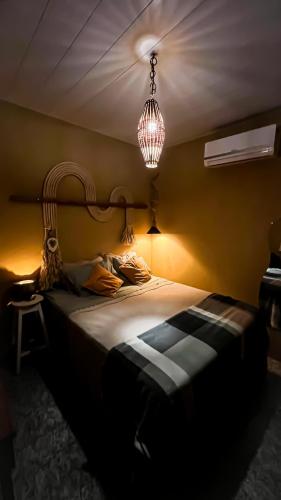 a bedroom with a large bed with a chandelier at Casinha Aconchegante em Alter do Chão 2min da ilha in Alter do Chao
