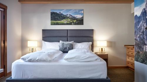 a bedroom with a bed with white sheets and pillows at Landhaus Erika in Leavenworth