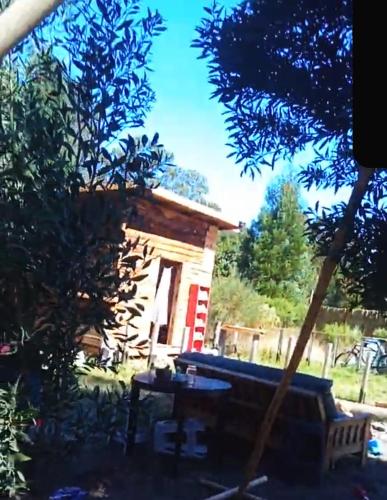 マル・デル・プラタにあるCamping Sadhu Argentinaの庭にベンチ付きのログキャビン