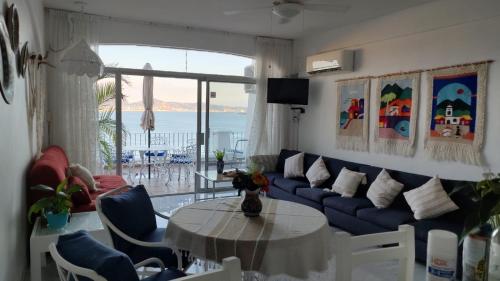 a living room with a blue couch and a table at Hermoso condominio en Bahía Manzanillo in Manzanillo