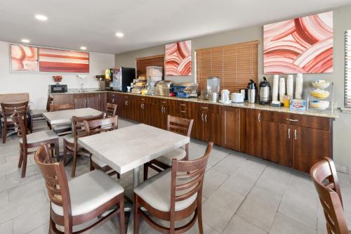 a restaurant with a table and chairs and a kitchen at SYLO Hotel Denver Airport, a Ramada by Wyndham in Aurora