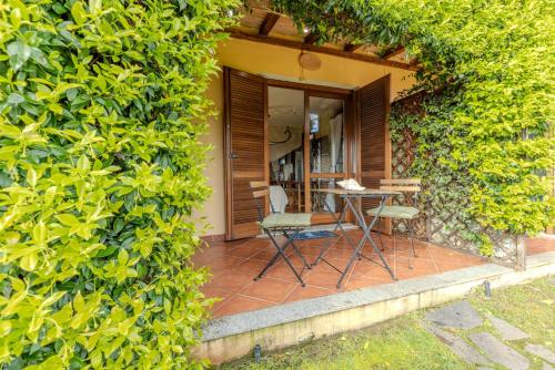 a patio with chairs and a table in a hedge at Lulamax Sardegna in Budoni