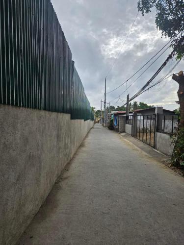 an empty street with a fence on the side at Mel's Place Batangas Unit 2 Two Bedroom House w Free Parking WIFI Smart TV Netflix Hot & Cold Shower in Batangas City