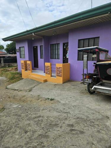 a purple house with a car parked in front of it at Mel's Place Batangas Unit 2 Two Bedroom House w Free Parking WIFI Smart TV Netflix Hot & Cold Shower in Batangas City