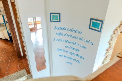 a sign on a wall with writing on it at Lulamax Sardegna in Budoni