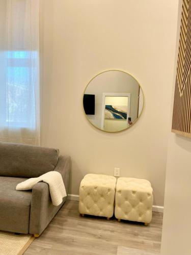 a living room with a couch and a mirror at Central 2BR Near Yale WiFi with Washer and Dryer in New Haven