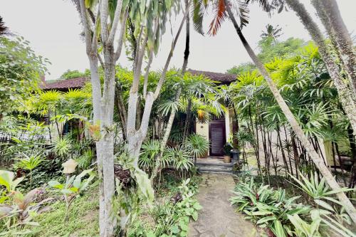 a house with palm trees in front of it at Raja's Bungalows in Senggigi