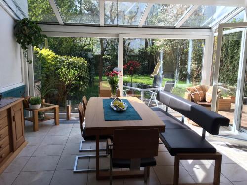 una sala da pranzo con giardino d'inverno, tavolo e sedie di Bed & Breakfast Faas a Wittlich
