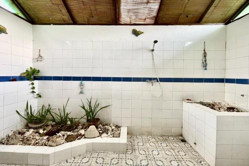 a bathroom with a bathtub with plants in it at Raja's Bungalows in Senggigi
