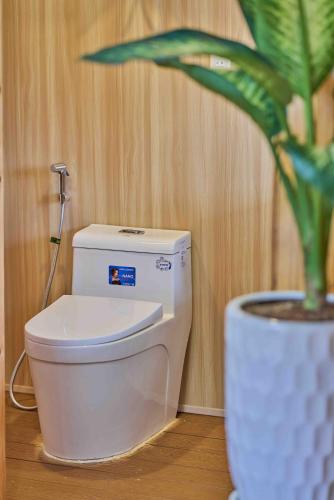 a bathroom with a toilet and a potted plant at Lan Ha Floating Homestay in Cat Ba