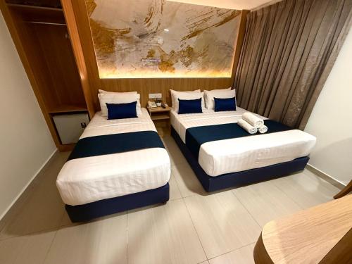 two beds in a hotel room with two bedsvisor at ESSY Hotel KL Sentral in Kuala Lumpur