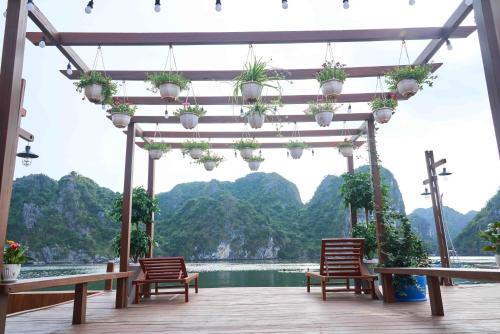 a pergola with chairs and a view of the water at Lan Ha Floating Homestay in Cat Ba