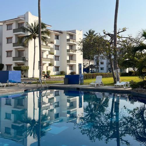 a swimming pool in front of a apartment building at Departamento en suites palmas, con club de playa in Manzanillo