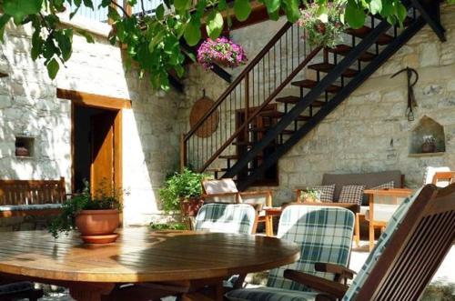 a wooden table and chairs in a patio with stairs at Narkissos Villa in Kallepia