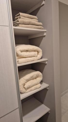 a closet with white towels sitting on shelves at LA RIVIERA Copahue - CON COCHERA in Villa María