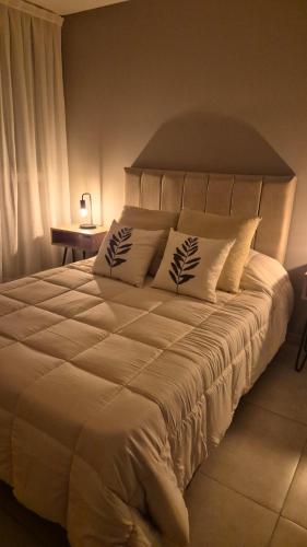 a bedroom with a large white bed with pillows at LA RIVIERA Copahue - CON COCHERA in Villa María