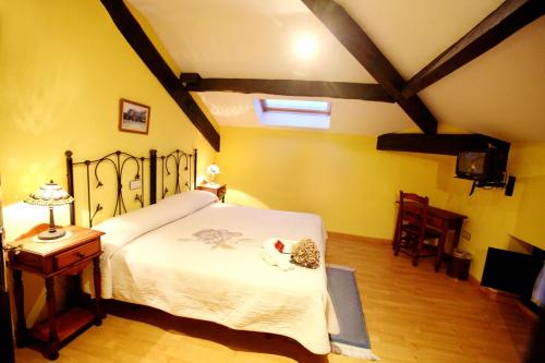 a bedroom with a white bed and a wooden floor at Hotel Casa de Indianos Don Tomás in Nueva de Llanes