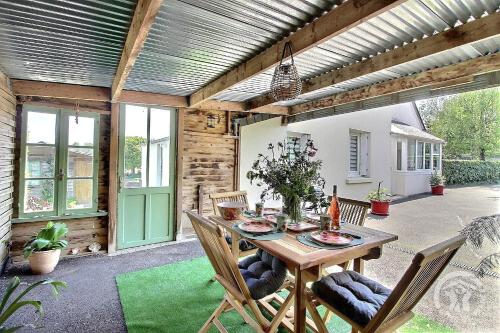 un patio avec une table et des chaises en bois dans l'établissement Keryvane, à Plourivo