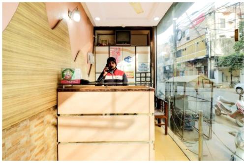 a woman is sitting at a counter in a restaurant at HOTEL PREMIUM SUNRISE Near Hanuman Temple and Railway Station - Parking and Wifi Facilities - Air Conditioning Luxury Room - A Top Rated Four Star Hotel in Lucknow