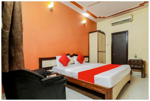 a bedroom with a large bed with orange walls at HOTEL PREMIUM SUNRISE Near Hanuman Temple and Railway Station - Parking and Wifi Facilities - Air Conditioning Luxury Room - A Top Rated Four Star Hotel in Lucknow
