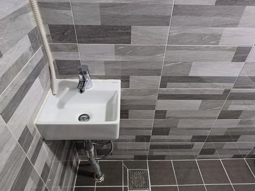 a white sink in a bathroom with a tile floor at Tongyeong Bridge Hotel in Tongyeong