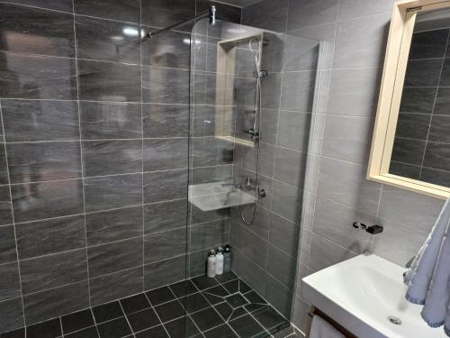 a bathroom with a shower and a sink at Tongyeong Bridge Hotel in Tongyeong