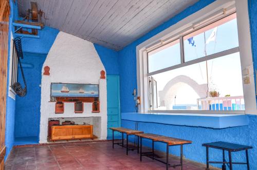 ein blaues Zimmer mit 2 Tischen und einem Fenster in der Unterkunft Villa Nanita in Pláka