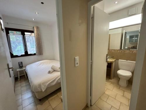 a bedroom with a bed and a toilet and a sink at Résidence Capizzolu in Cargèse