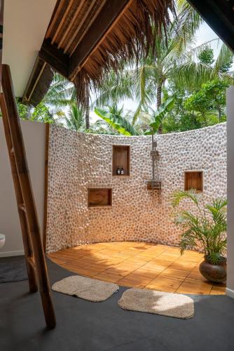 a room with a brick wall and a floor with rugs at U Story Resort in Siquijor